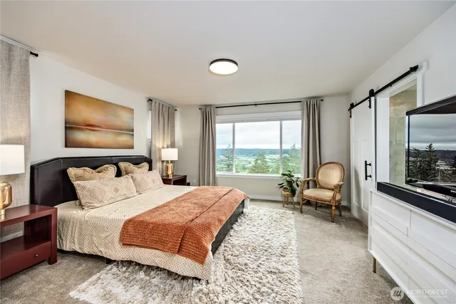 a bedroom with a bed a couch and large window