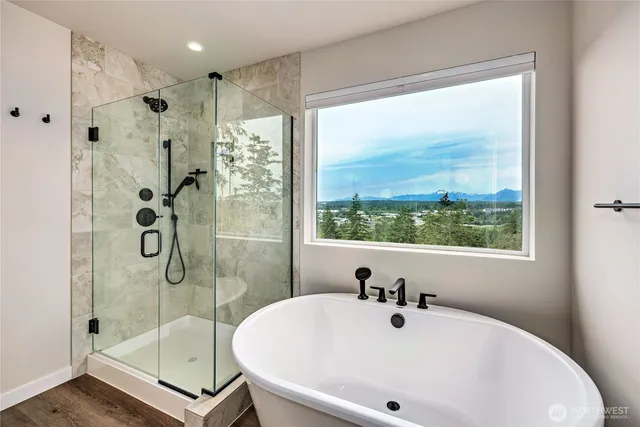 a bathroom with a tub a sink and glass door