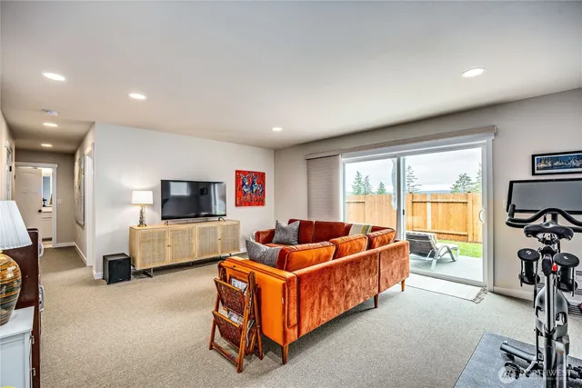 a living room with furniture a flat screen tv and a large window
