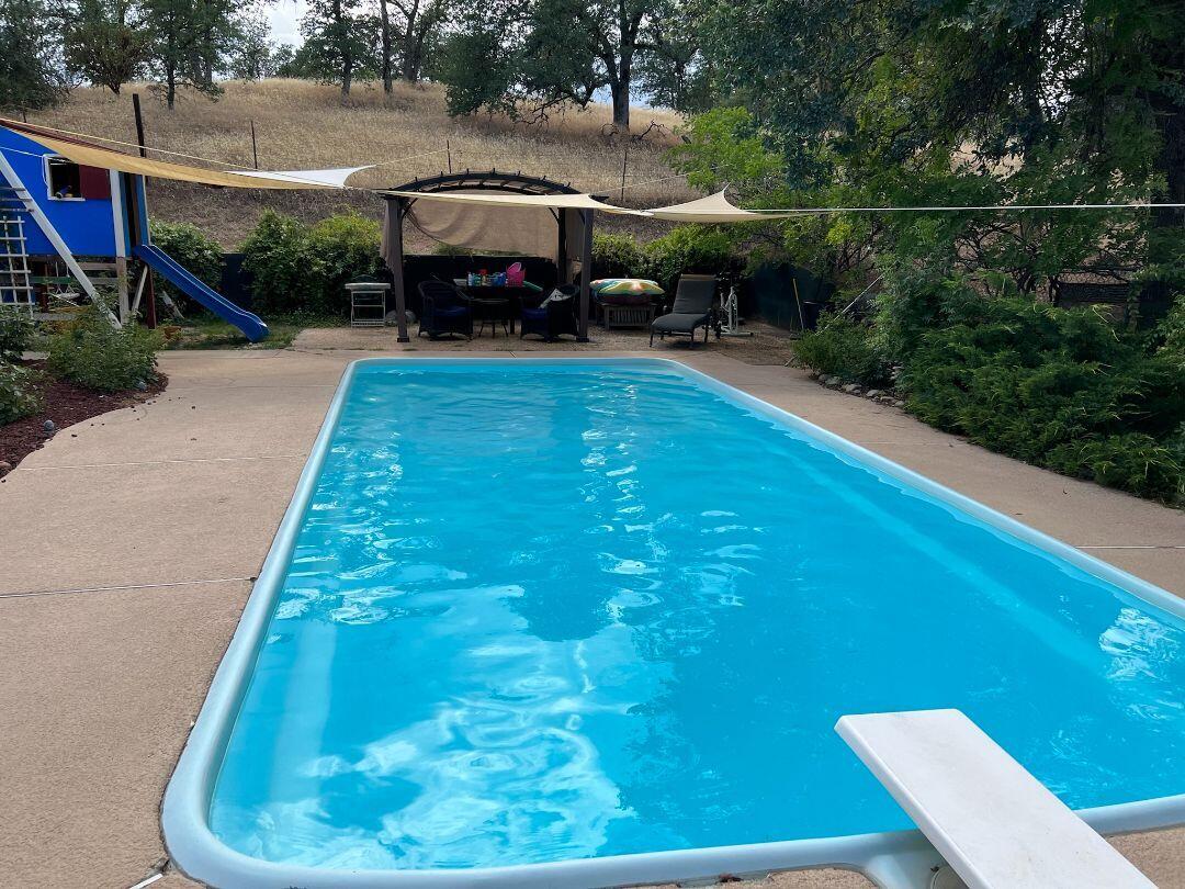 9733 Hidden Lane Palo Cedro, CA 96073 - Photo 34 of 63 a view of a yard with table and chairs under an umbrella