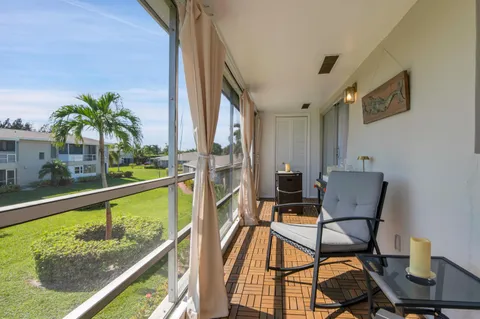 a view of a chairs and table in patio with a lake view