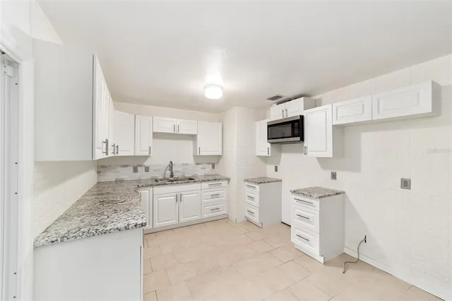 a view of a yard with plants and large trees