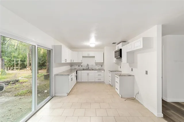 a view of a house with backyard and trees