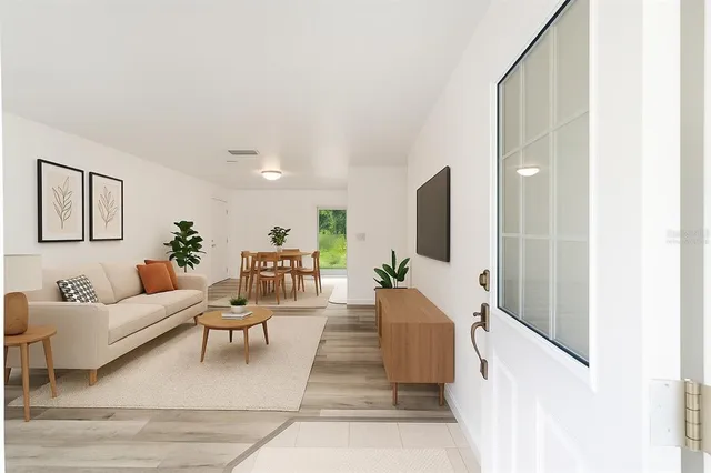 a dining room with furniture and a potted plant