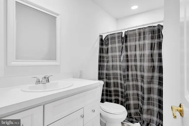 a bathroom with a sink a toilet a mirror and shower