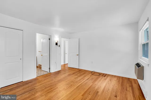 a view of a big room with wooden floor and a window