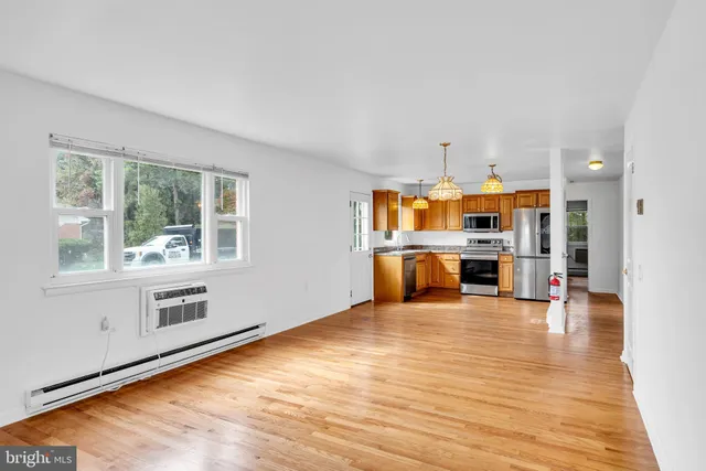 a living room with stainless steel appliances kitchen island granite countertop a stove and a large window