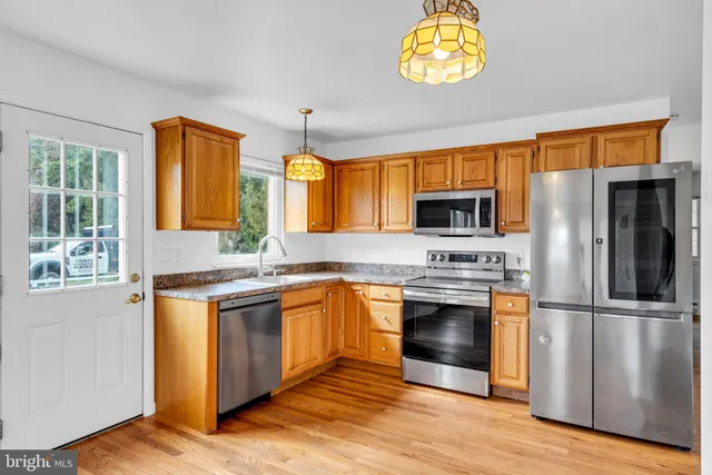 a kitchen with stainless steel appliances granite countertop a stove a sink and a refrigerator