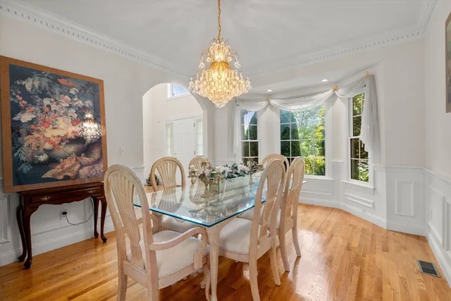 a dining room with furniture a chandelier and wooden floor