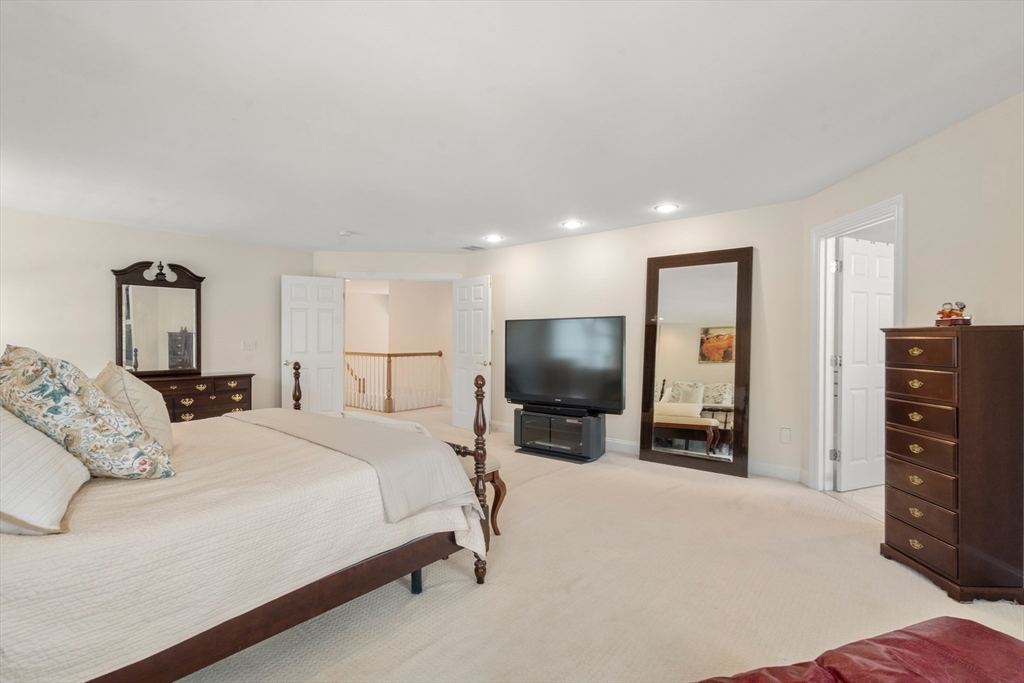 21 Whispering Lane Natick, MA 01760 - Photo 19 of 41 a bedroom with a bed and a flat screen tv