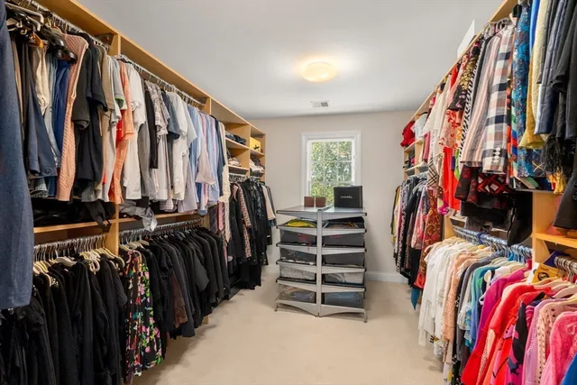 a view of walk in closet with clothes and shoes
