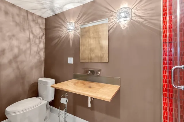 a bathroom with a granite countertop sink a toilet and a mirror