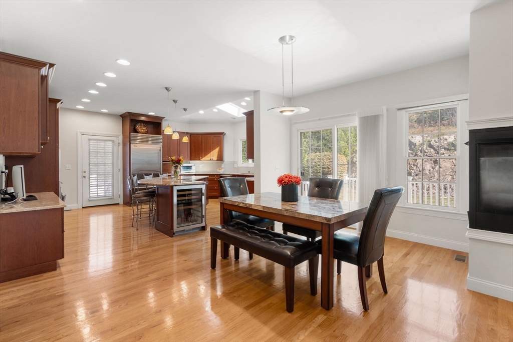 21 Whispering Lane Natick, MA 01760 - Photo 5 of 41 a view of a dining room and livingroom with furniture wooden floor a rug a fireplace and a chandelier