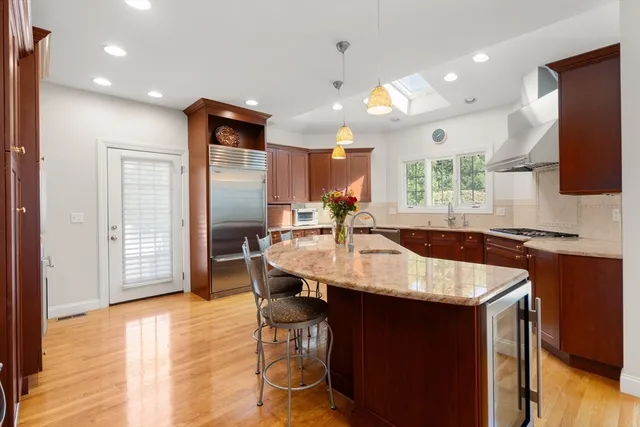 a kitchen with stainless steel appliances granite countertop a sink a stove and a refrigerator
