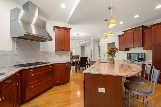a large kitchen with stainless steel appliances granite countertop a sink a stove and a refrigerator