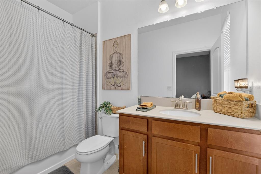 11439 Crowne Pointe Street New Port Richey, FL 34654 - Photo 16 of 50 a bathroom with a granite countertop sink toilet and mirror
