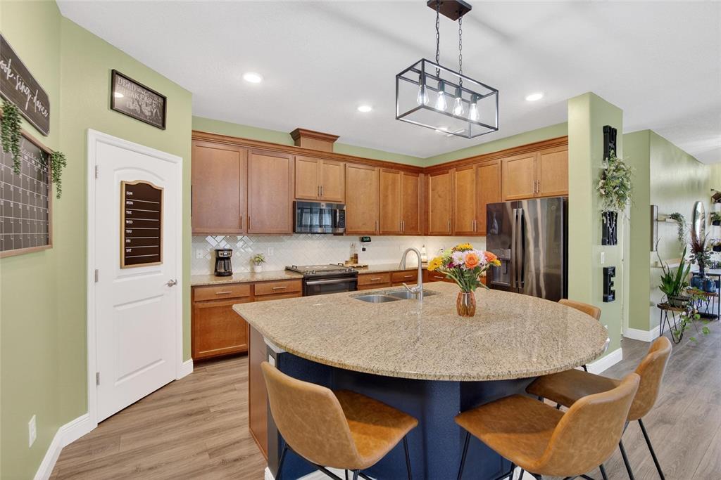 11439 Crowne Pointe Street New Port Richey, FL 34654 - Photo 20 of 50 a kitchen with stainless steel appliances granite countertop a kitchen island a stove a table and chairs