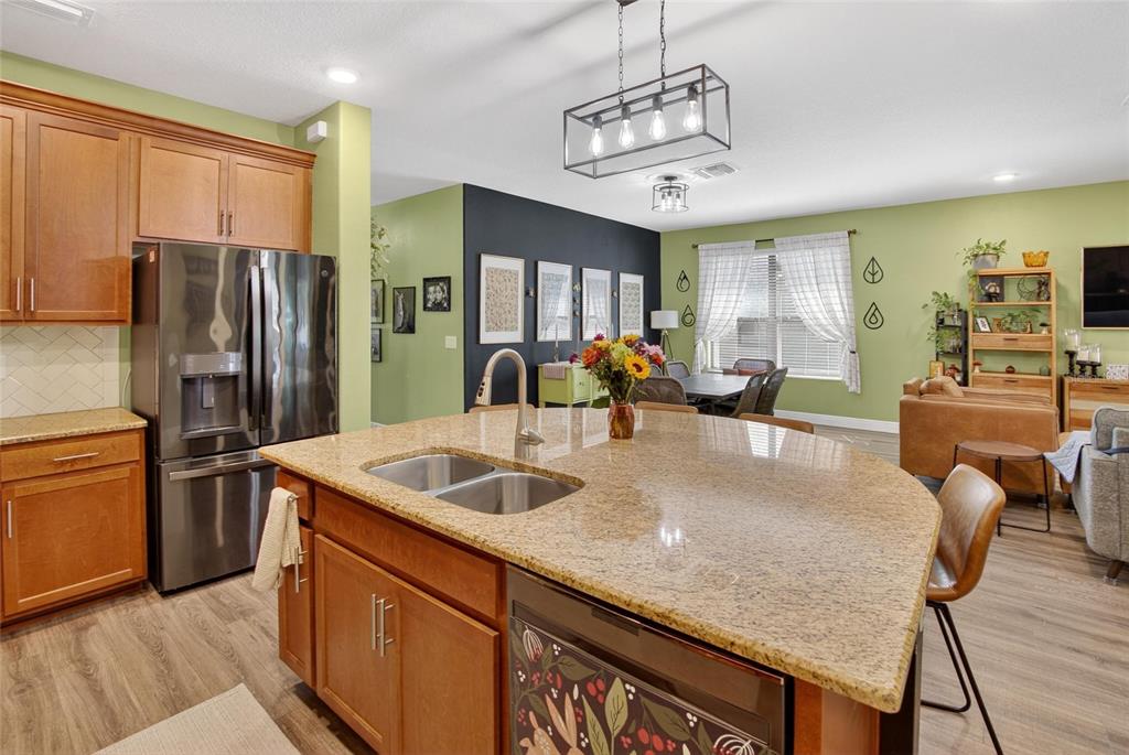 11439 Crowne Pointe Street New Port Richey, FL 34654 - Photo 21 of 50 a kitchen with stainless steel appliances granite countertop a sink refrigerator and cabinets