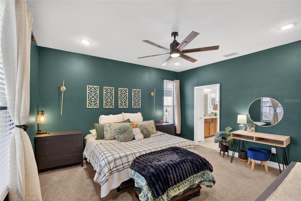 11439 Crowne Pointe Street New Port Richey, FL 34654 - Photo 31 of 50 a bedroom with a bed and a chandelier