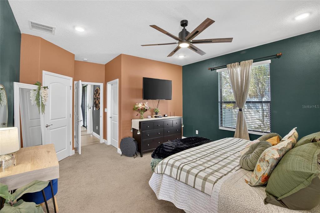 11439 Crowne Pointe Street New Port Richey, FL 34654 - Photo 33 of 50 a bedroom with a large bed and a flat screen tv