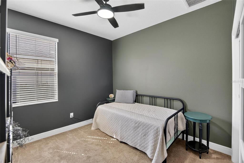 11439 Crowne Pointe Street New Port Richey, FL 34654 - Photo 8 of 50 a bedroom with a bed and a ceiling fan