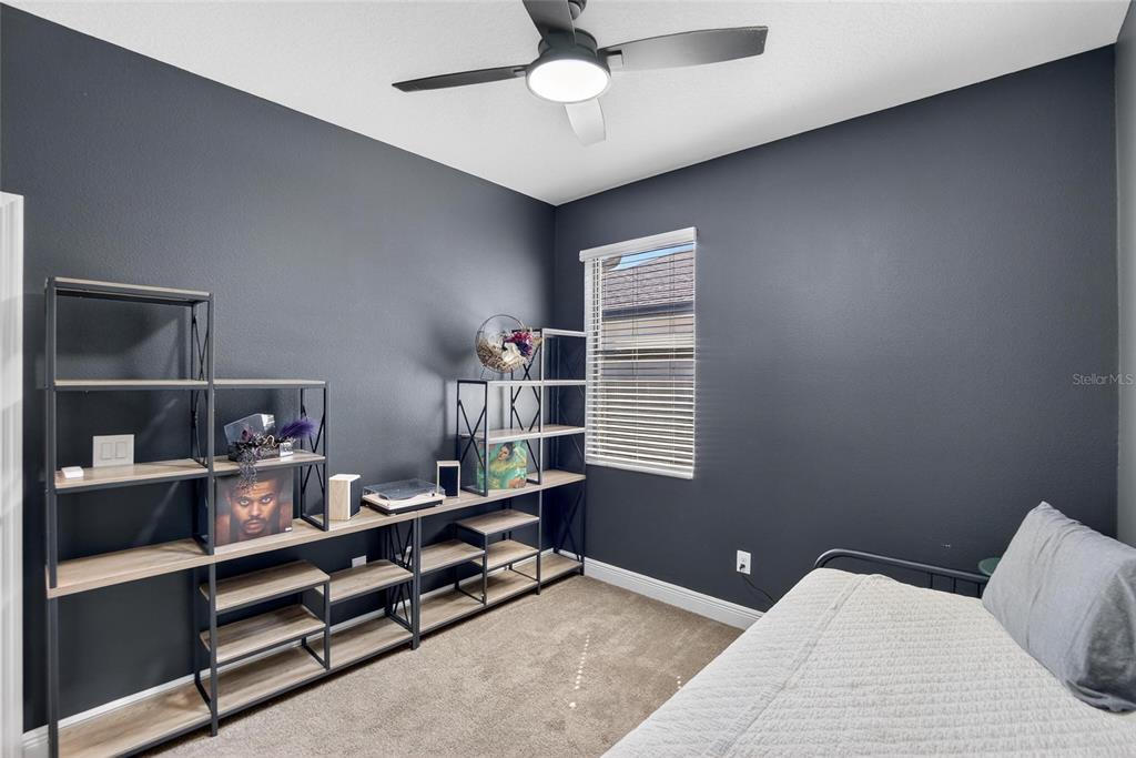 11439 Crowne Pointe Street New Port Richey, FL 34654 - Photo 9 of 50 a bedroom with a bed and a chandelier