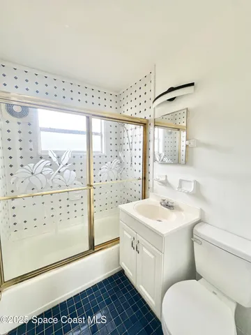 a bathroom with a sink a toilet and a large mirror