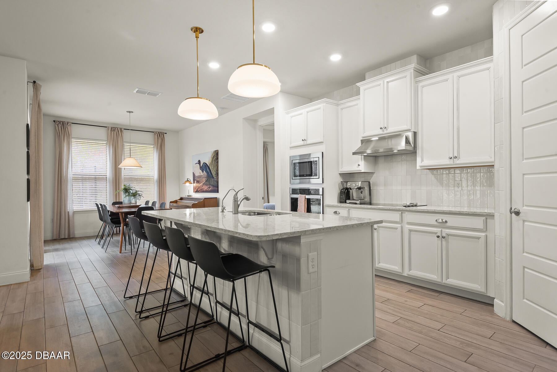 2853 Monaghan Drive Ormond Beach, FL 32174 - Photo 8 of 47 a kitchen with stainless steel appliances kitchen island granite countertop a table chairs sink and cabinets