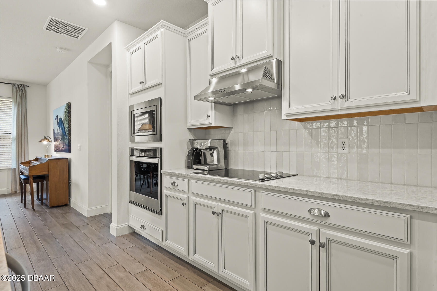 2853 Monaghan Drive Ormond Beach, FL 32174 - Photo 10 of 47 a kitchen with stainless steel appliances white cabinets and a wooden floor