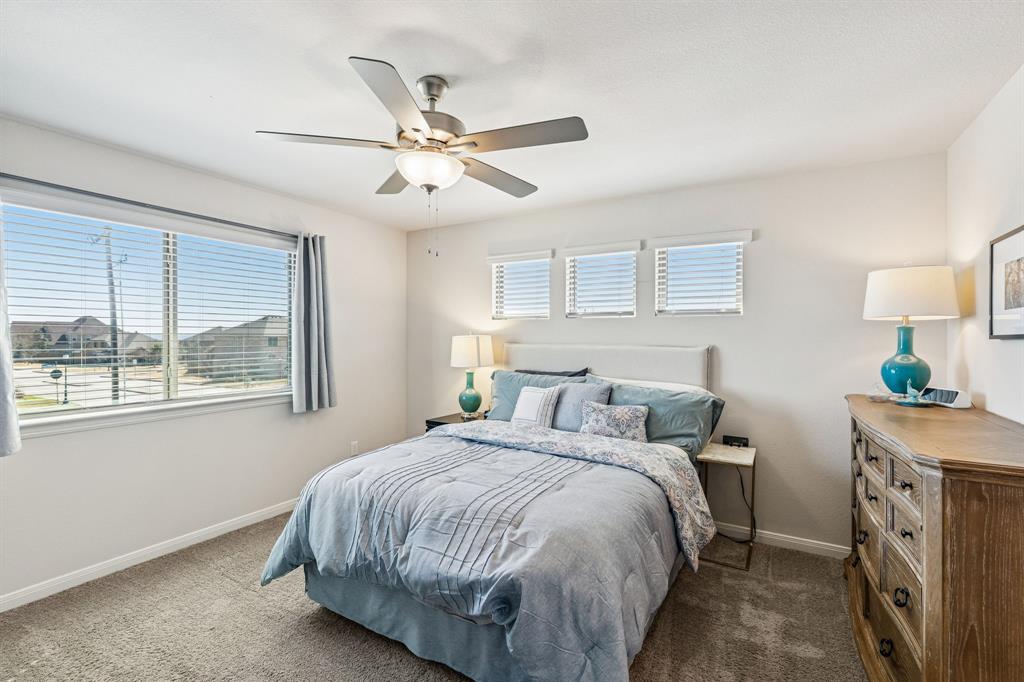 3236 Patrick Street Wylie, TX 75098 - Photo 15 of 35 a bedroom with a bed and a chandelier