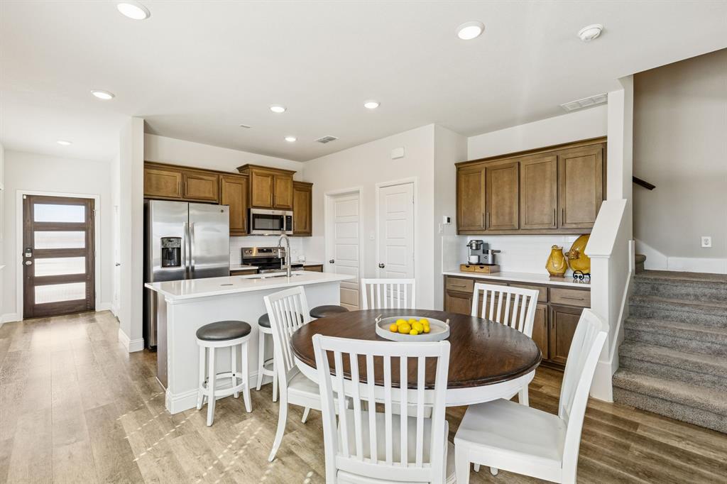 3236 Patrick Street Wylie, TX 75098 - Photo 6 of 35 a kitchen with a dining table chairs and refrigerator