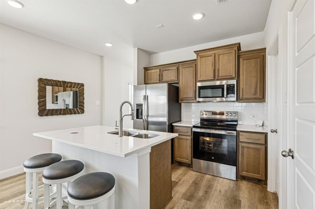 3236 Patrick Street Wylie, TX 75098 - Photo 8 of 35 a kitchen with stainless steel appliances a microwave sink stove and refrigerator