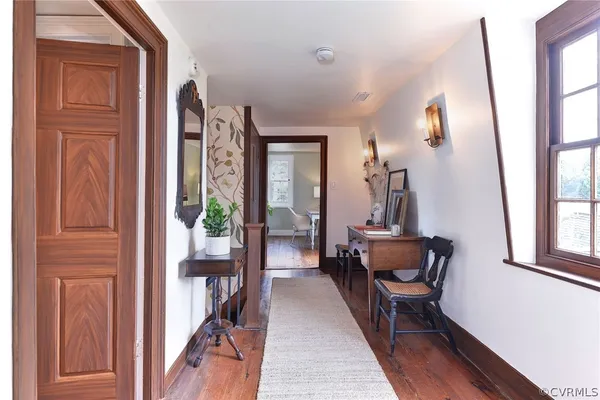 a hallway with a large mirror and furniture