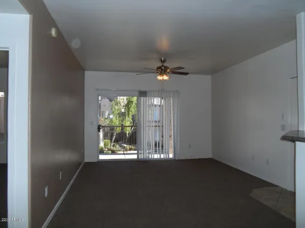 en empty room with windows and ceiling fan
