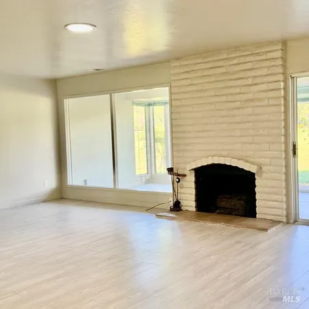 an empty room with a fireplace and window