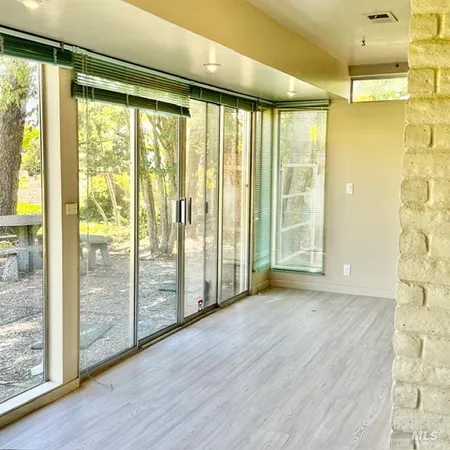 a view of a room with wooden floor and doors