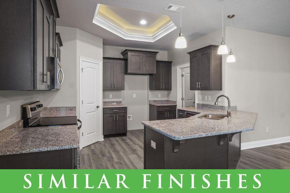 8543 Laredo Street Navarre, FL 32566 - Photo 4 of 14 a kitchen with kitchen island granite countertop a sink cabinets and stainless steel appliances