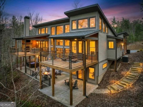 a view of a backyard with plants and large tree