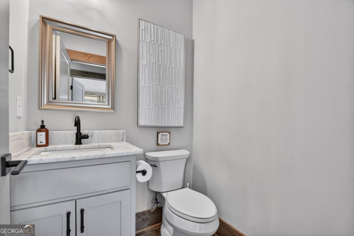 466 Watersong Bluff West Ellijay, GA 30540 - Photo 23 of 67 a bathroom with a toilet sink vanity and mirror