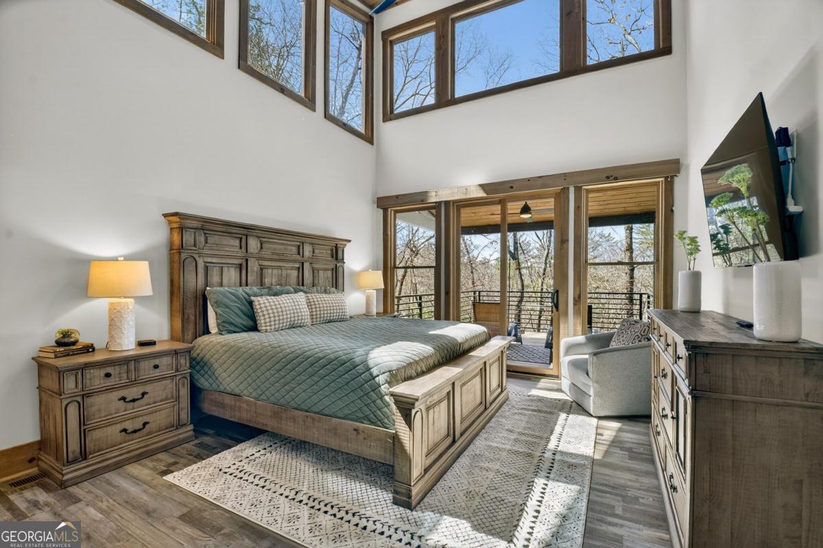 466 Watersong Bluff West Ellijay, GA 30540 - Photo 30 of 67 a bedroom with a large bed and a flat tv screen on dresser