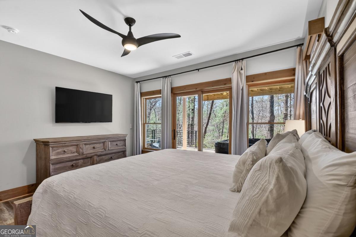 466 Watersong Bluff West Ellijay, GA 30540 - Photo 49 of 67 a bedroom with a large bed and a flat screen tv