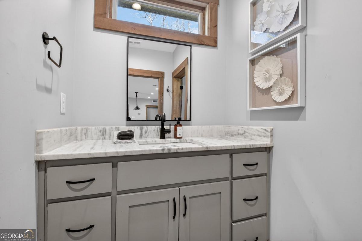 466 Watersong Bluff West Ellijay, GA 30540 - Photo 52 of 67 a bathroom with a granite countertop sink and a mirror