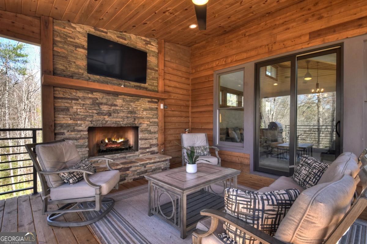 466 Watersong Bluff West Ellijay, GA 30540 - Photo 58 of 67 a living room with furniture a flat screen tv and a fireplace