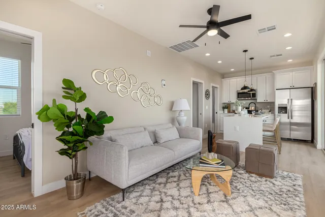 a living room with furniture potted plant and kitchen view