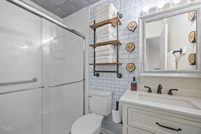 a bathroom with a sink a toilet and shower