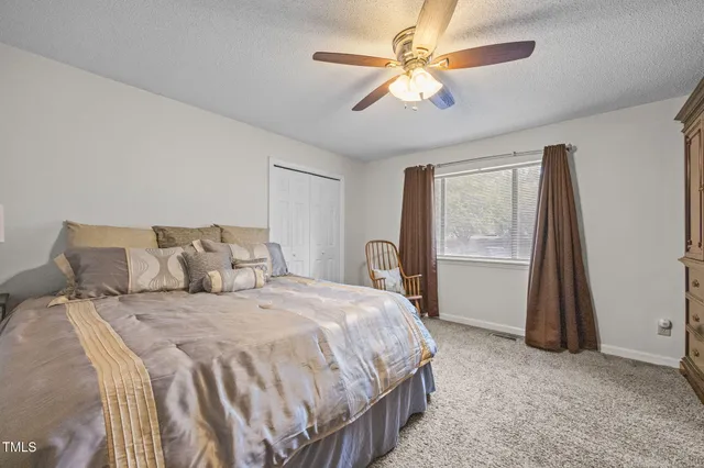 a spacious bedroom with a bed and a chandelier