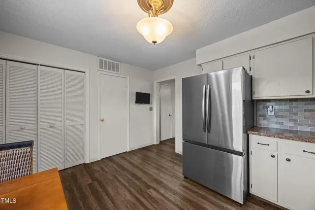 a kitchen with stainless steel appliances granite countertop a refrigerator and a stove top oven