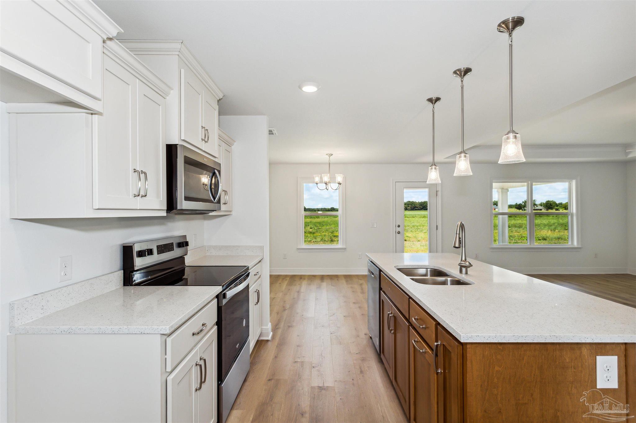 9319 Salter Road Pace, FL 32571 - Photo 12 of 32 a kitchen with a stove a sink and a refrigerator