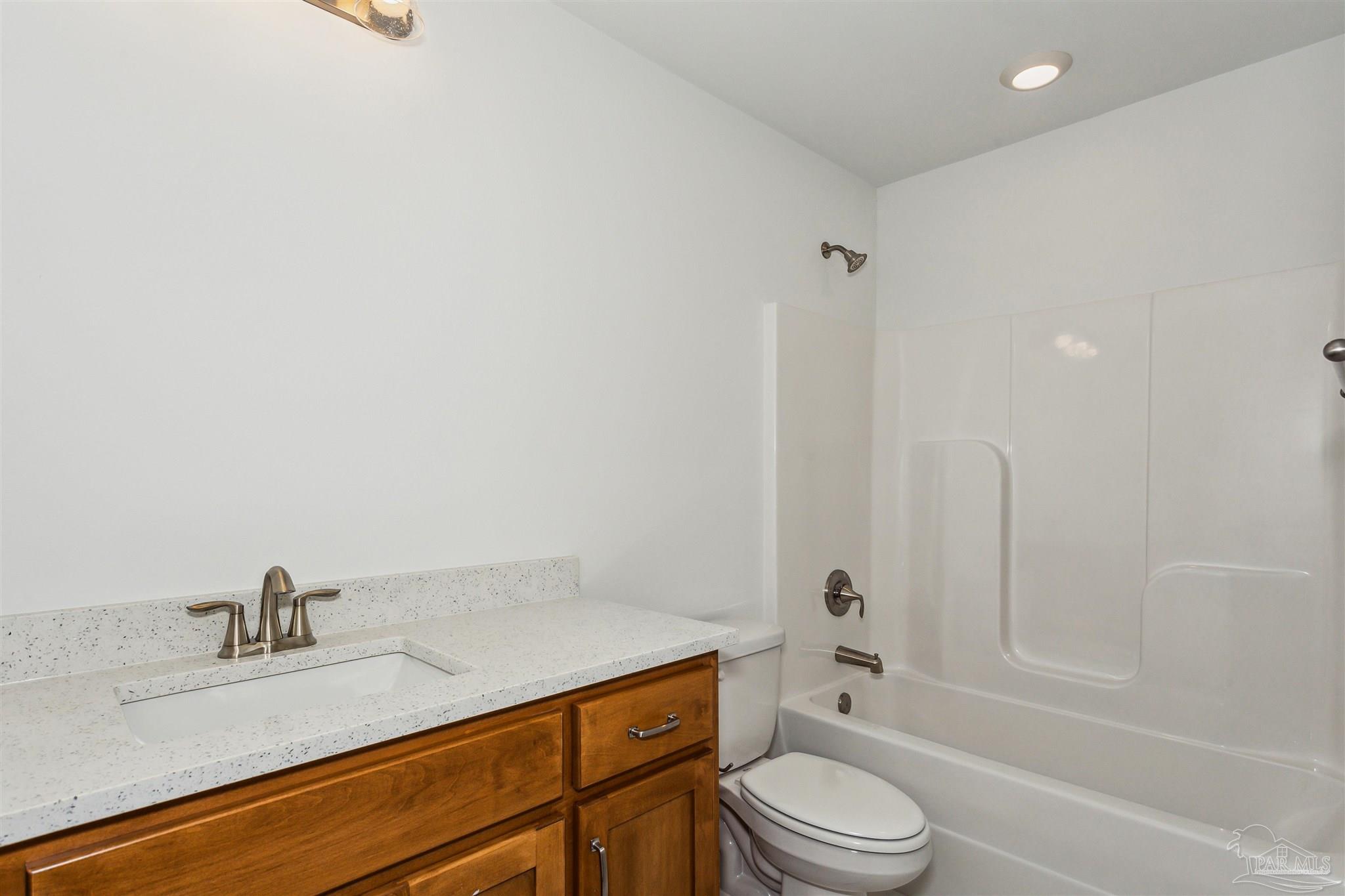 9319 Salter Road Pace, FL 32571 - Photo 21 of 32 a bathroom with a granite countertop sink toilet a mirror and shower