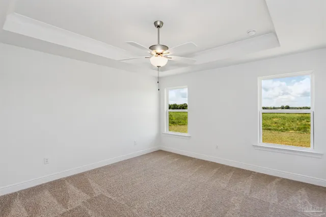 an empty room with windows and fan